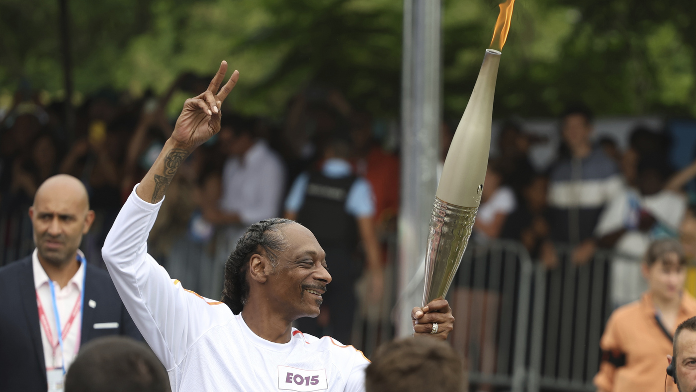 Snoop Dogg carries the Olympic torch before opening ceremony in Paris